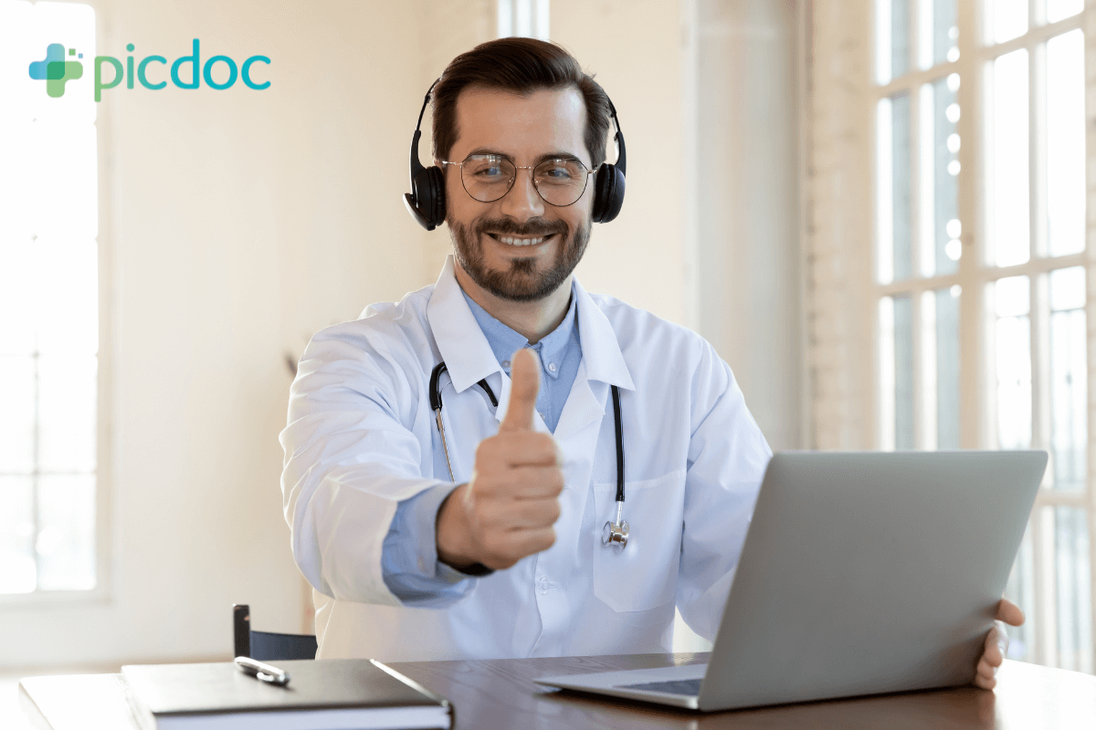 medico-a-frente-de-computador-fazendo-sinal-de-positivo